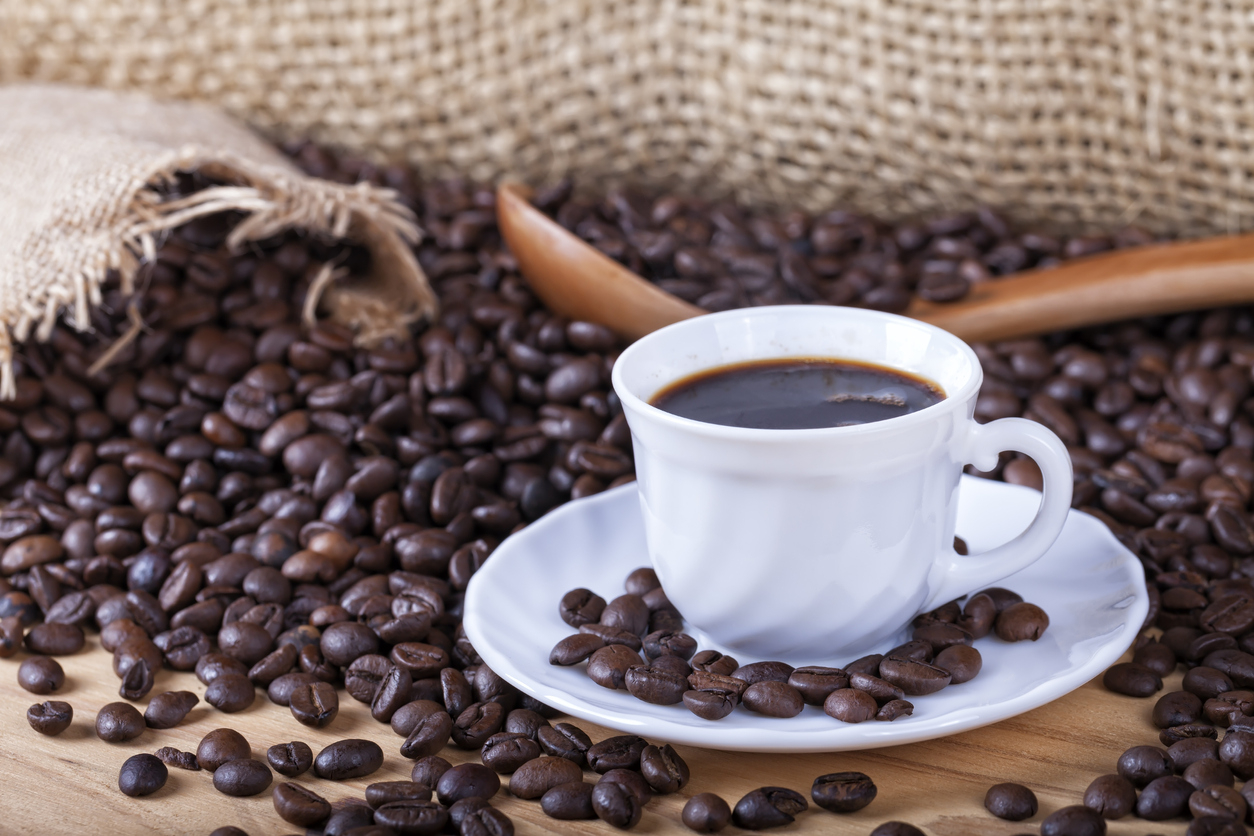 Une tasse de café avec des grains autour