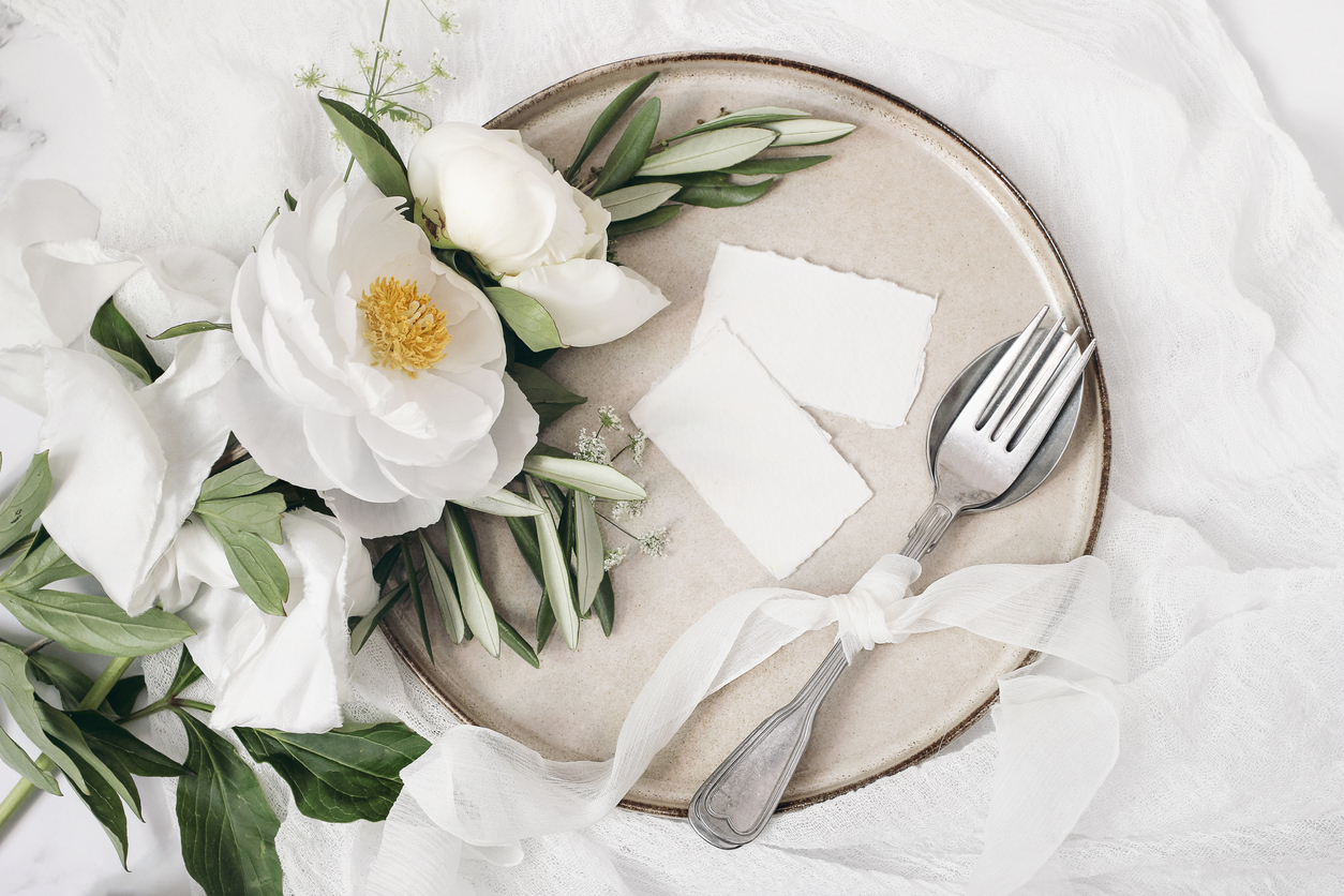 Une assiette en céramique avec des fleurs blanches dessus